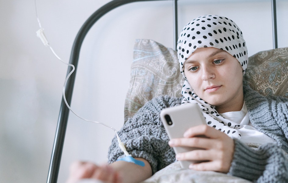 A-Women-is-undergoing-chemo-treatment-and-is-looking-at-her-smartphone-seeing-the-effects-of-chemotherapy